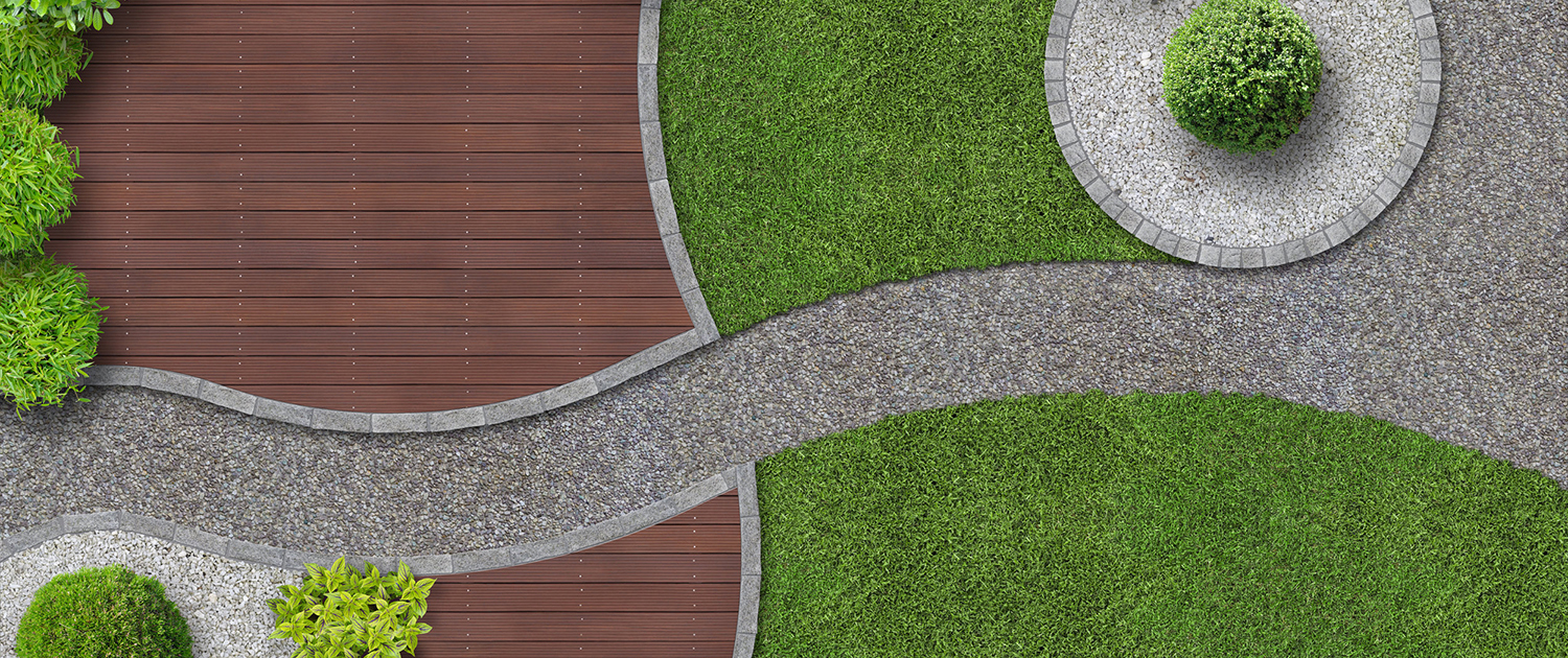 Aerial view of a landscaped garden designed by Pool Builders Brisbane, featuring a curved gravel path dividing wooden decking and green grass areas. Circular sections of gravel with trimmed bushes are positioned at the corners. Lush green foliage borders the top and lower sections.